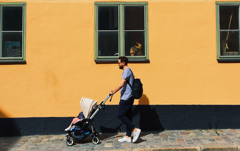 father pushing a stroller down street